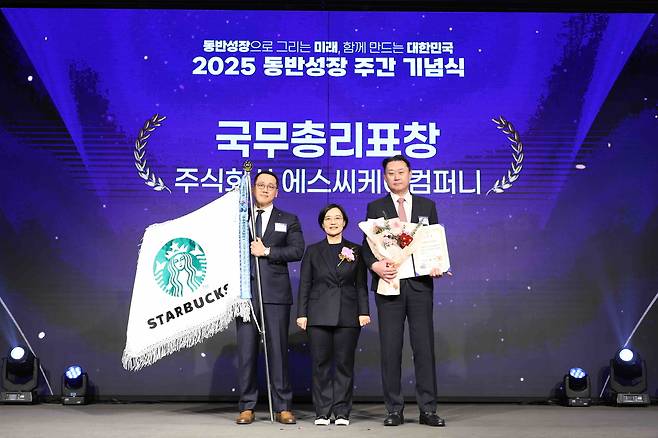 Starbucks Korea CEO Son jung-hyun (right) and Minister of Small, Medium-sized Enterprises and Startups Han Seong-sook (center) pose for a photo during the 2025 Shared Growth Week Ceremony at the KBIZ Hall in Seoul on Tuesday. (Starbucks Korea)