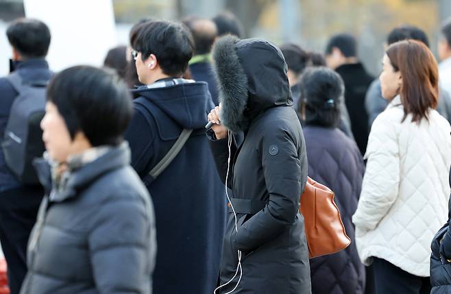 People dressed in heavy winter clothing walk through the Gwanghwamun intersection in Jongno District, central Seoul, on the morning of Nov. 26 [NEWS1]