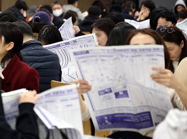 16일 서울의 한 학원에서 열린 수능 가채점 설명회에서 학부모들이 대입 지원 관련 자료를 살피고 있다. [연합]