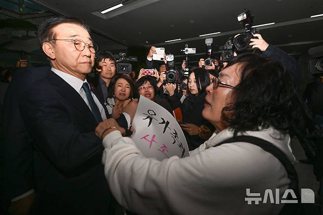 [무안=뉴시스] 이영주 기자 = 김윤덕(왼쪽) 국토교통부 장관이 26일 오후 전남 무안군 무안국제공항에서 12·29 무안공항 제주항공 여객기 참사 유가족들과 면담을 시도하다 국토부 항공철도사고조사위원회의 제주항공 참사 조사결과 공청회 개최 중단을 촉구하는 유가족들의 항의를 받고 있다. 2025.11.26. leeyj2578@newsis.com