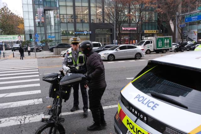 경찰이 무면허 전기자전거 운전자를 적발하고 있다. 황동건 기자