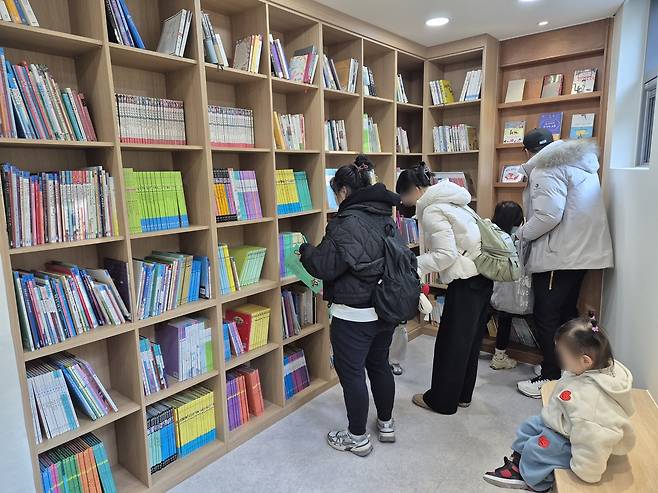 숲속 책 쉼터 관리동에 설치된 도서관  (대구=연합뉴스) 박세진 기자 = 26일 대구 남구가 개장한 앞산 숲속 책 쉼터 관리동에 설치된 도서관을 방문객들이 이용하고 있다. 2025.11.26 psjpsj@yna.co.kr