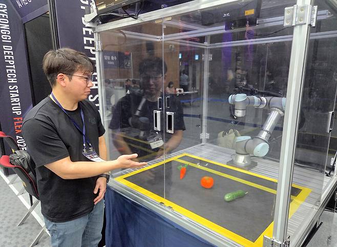 ▲ 27일 경기 딥테크 스타트업 2025의 일환으로 열린 기업 부스 모습. 스마트업 지원 업체인 TMS는 로봇팔을 선보이고 있다.