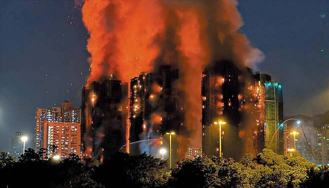 AFP 연합뉴스화염·연기에 휩싸인 아파트 26일 홍콩 타이포 지역 아파트 단지 왕푹코트에서 발생한 대형 화재로 건물 여러 채가 화염과 연기에 휩싸여 있다. 건물 외벽 공사를 위해 설치돼 있던 대나무 비계가 화재를 키운 것으로 추정된다.