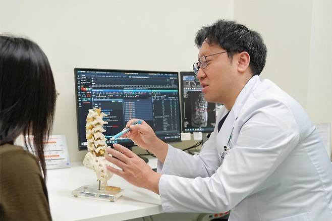 박종혁  분당제생병원 척추센터 신경외과 과장이 척추 모형을 가리키며 환자에게 허리 통증에 관해 설명하고 있다.
분당제생병원 제공