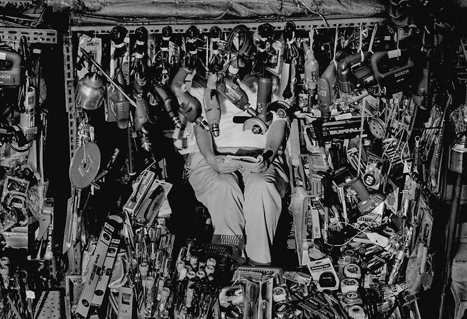 한 평 남짓한 비좁은 공간에 마치 설치예술인 것처럼 빽빽하게 팔 물건들을 진열해놓았다. 그 안에 비집고 앉아 종일 손님을 기다리며 독서 중인 공구 노점상. 세운상가, 1997.