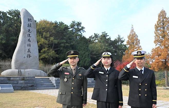 28일 임관하는 육다빈 해병소위(왼쪽), 이주리 해군소위(가운데), 이솔 해군소위(오른쪽)가 힘찬 경례를 하고 있다. 해군 제공