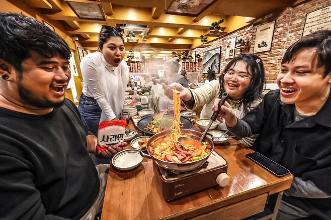 지난 24일 서울 서교동 홍대부대찌개를 찾은 태국 관광객들이 음식 앞에서 환호하고 있다. /주민욱 영상미디어 기자