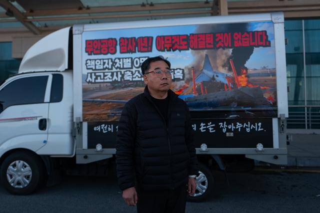 김영헌(53)씨가 26일 자신의 선전 트럭 앞에 서 있다. 그의 트럭엔 '무안공항 참사 1년! 아무것도 달라진 것이 없습니다', '여전히 피눈물 흘리는 유가족의 손을 잡아 주십시오'라는 문구가 화염에 휩싸인 항공기 사진과 함께 래핑돼 있다. 김씨는 지난 참사로 아내와 두 아들까지, 온 가족을 모두 잃었다. 무안=하상윤 기자