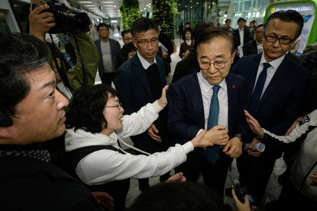 26일 유가족과의 면담을 위해 무안공항을 찾은 김윤덕 국토교통부 장관이 ‘항공철도사고조사위원회의 공청회 강행을 중단하라’는 유가족들의 강한 반발에 부딪히며 10여분만에 발길을 돌리고 있다. 김 장관의 옷자락을 붙들고 오열하는 이는 지난 참사에서 남편을 잃은 박귀숙(62)씨다. 무안=하상윤 기자