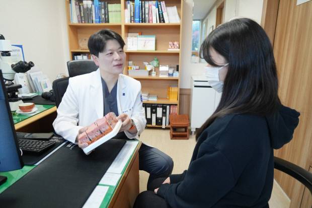 조선대병원 피부과 최훈 교수가 화농성 한선염 환자를 진료하고 있다.  <조선대병원 제공>