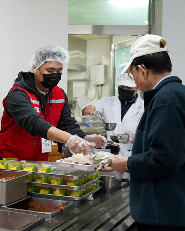 LG전자 임직원들로 구성된 ‘라이프스굿 봉사단’이 구립용산장애인복지관 이용자들에게 김장 김치와 수육 등으로 구성된 나눔 밥상을 전달하는 모습.(사진=LG전자)