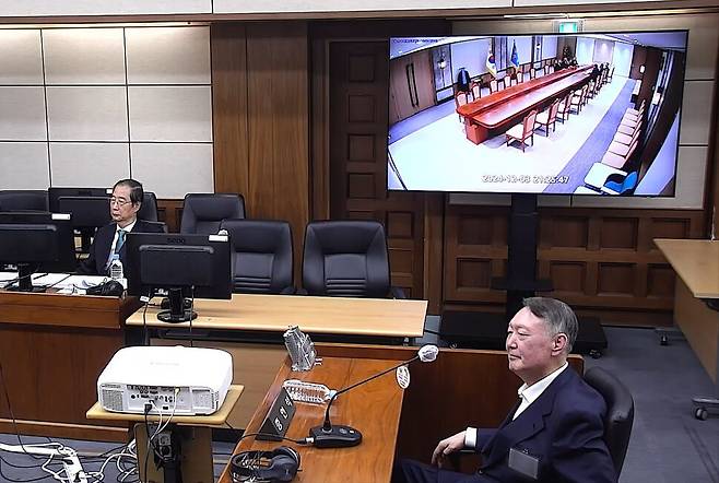 윤석열 전 대통령(오른쪽)이 11월 19일 오후 서울 서초구 서울중앙지법에서 열린 한덕수 전 국무총리(왼쪽) 내란 재판에 증인으로 출석해 비상계엄 당일 대통령실 국무회의 폐회로텔레비전(CCTV)을 지켜보고 있다. 서울중앙지법 제공