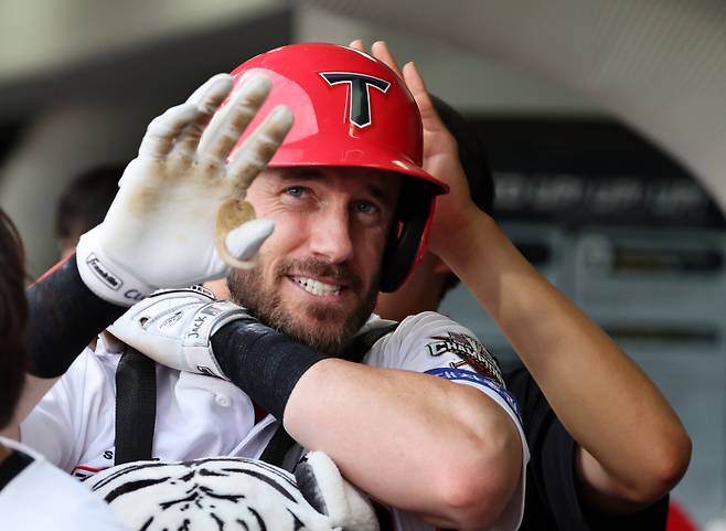 <yonhap photo-5521="">2일 광주기아챔피언스필드에서 열린 프로야구 SSG 랜더스와 KIA 타이거즈의 경기. KIA 위즈덤이 1회말에 솔로홈런을 치고 홈인한 뒤 더그아웃에서 미소 짓고 있다. 2025.7.2 [연합뉴스]</yonhap>