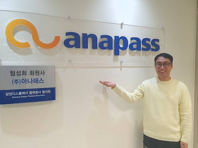 정유진 부장이 회사 로고 앞에서 포즈를 취하고 있다. 윤현주 기자