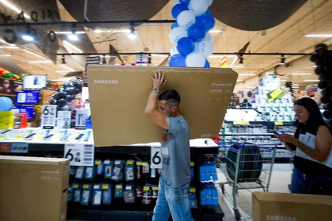 2025년 11월 27일 브라질 상파울루의 한 대형마트에서 한 소비자가 블랙프라이데이 세일 기간 TV를 구매하고 있다. [사진= AFP 연합뉴스]