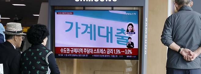 서울역 대합실에서 가계대출 관련 뉴스를 시민들이 시청하고 있다. [김호영 기자]