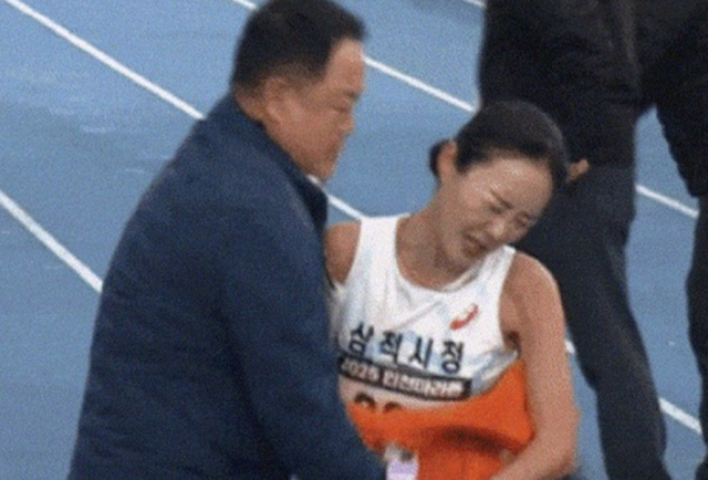 ▲2025 인천국제마라톤 국내 여자부 우승자 이수민 선수가 지난 23일 대회에서 결승선을 통과한 직후 자신을 막아세운 소속팀 김완기 감독을 뿌리치는 모습 ⓒ유튜브 화면 캡처