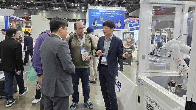 로보월드 2025에서 김진배 아라 대표가 해외 바이어에게 제품을 소개하고 있다.