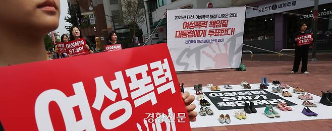 서울여성회 페미니스트 대학생연합동아리 회원들이 지난 4월27일 서울 마포구 홍대입구역 앞에서 열린 ‘2025 대선, 여성폭력 해결! 나중은 없다!’ 캠페인에서 여성폭력 희생자들을 상징하는 신발을 놓고  다이-인(Die-in) 퍼포먼스를 하고 있다. 성동훈 기자