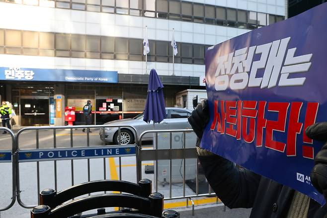 더불어민주당 대의원·전략지역 당원 역할 재정립 태스크포스가 1일 여의도 민주당사에서 ‘당원주권 정당 실현을 위한 제도 개선 토론회’를 여는 가운데 한 시민이 정청래 민주당 대표를 규탄하는 내용의 손팻말을 들고 있다. 연합뉴스