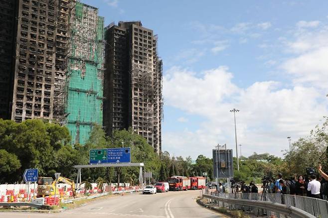대형 화재가 발생한 홍콩 북부 타이포 아파트 단지 '웡 푹 코트' 앞에서 취재진과 주민들이 참사 현장을 바라보고 있다. 연합뉴스