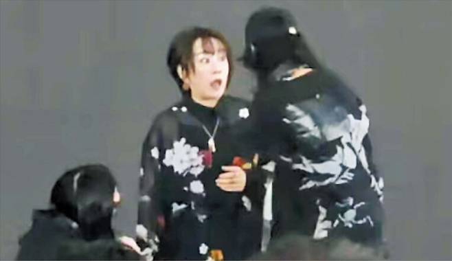 지난 28일 중국 상하이에서 공연 중이던 일본 가수 오쓰키 마키(가운데)가 현장 진행 요원들이 다가와 퇴장을 요청하자 놀란 표정을 짓고 있다. 중국 관객들이 노래를 따라 부르던 중 음악과 조명이 꺼졌고 오쓰키는 쫓기듯 무대에서 내려갔다. /X