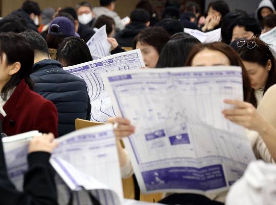 지난달 16일 서울의 한 학원에서 열린 수능 가채점 설명회에서 학부모들이 대입 지원 관련 자료를 살피고 있다. 연합뉴스