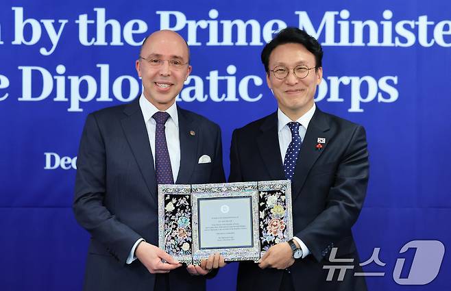 김민석 국무총리가 3일 서울 중구 소공동 롯데호텔에서 열린 국무총리 주최 주한 외교단 초청 리셉션에서 주한 외교단장인 샤픽 하샤디 주한모로코대사로부터 감사패를 받고 있다. 2025.12.3/뉴스1 ⓒ News1 임세영 기자