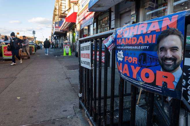 A campaign poster for New York City Mayor-elect Zohran Mamdani is displayed on a fence on Nov. 6 in the Brooklyn borough of New York City. With the election of Zohran Mamdani as New York City's next mayor, a new focus is being placed on the high cost of living in one of the world's most expensive cities. Mamdani pledged on the campaign trail to freeze rents, tax the wealthy, and provide free buses for New Yorkers, among other issues. It is estimated that the cost of living in New York City is 132 percent higher than the national average. [AFP/YONHAP]