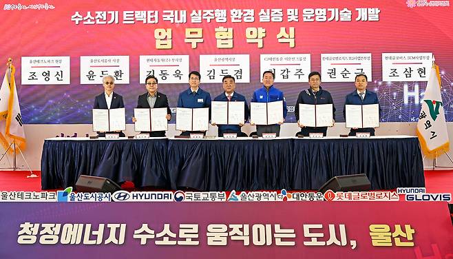 조영신(왼쪽부터) 울산테크노파크 원장, 윤두환 울산도시공사 사장, 김동욱 현대자동차 전략기획실장(부사장), 김두겸 울산광역시장, 최갑주 CJ대한통운 더운반그룹장, 권순근 롯데글로벌로지스 TLS사업본부장, 조삼현 현대글로비스 SCM사업부장이 2일 울산 태화강 국가정원 남구둔치에서 진행된 ‘수소전기 트랙터 국내 실주행 환경 실증 및 운영 기술 개발을 위한 다자간 업무협약’ 체결식에서 기념사진을 촬영하고 있는 모습. [현대자동차 제공]
