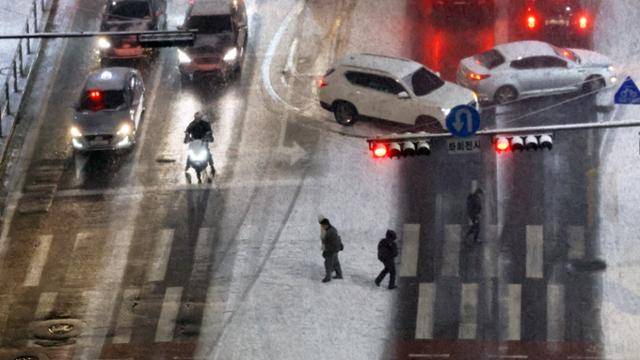 서울·인천·경기·강원 지역에 한 때 대설주의보 발효된 4일 저녁 서울 중구 도심에서 시민들이 횡단보도를 건너고 있다. 뉴시스