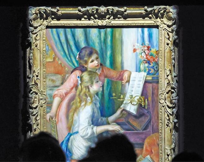 서울 용산동 국립중앙박물관의 ‘인상주의에서 초기 모더니즘까지, 빛을 수집한 사람들’ 전시 관람객들이 오귀스트 르누아르의 ‘피아노 치는 소녀들’을 감상하고 있다. 이 그림의 다른 버전이 지금 서초동 예술의전당에서 열리고 있는 오르세·오랑주리 미술관 전시에도 나와 있다. /뉴스1