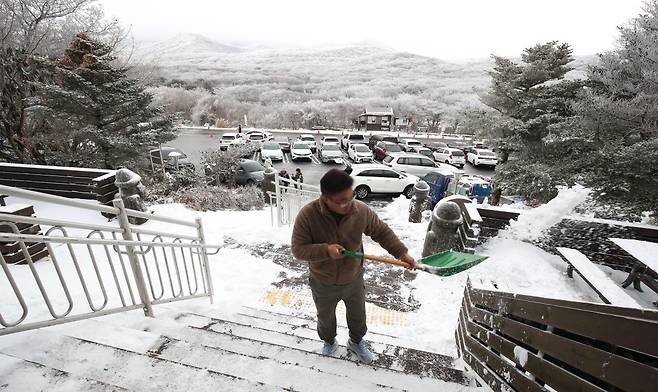 기습 추위가 절정에 달한 4일 오전 제주 한라산 1100고지 휴게소에서 관계자가 계단에 쌓인 눈을 치우느라 구슬땀을 흘리고 있다. 뉴시스