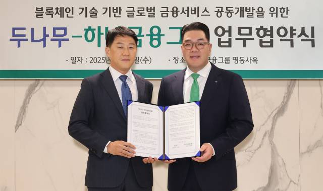 하나금융그룹이 이달 3일 오후 두나무와 블록체인 기술을 활용한 금융 서비스 공동 개발을 위한 업무협약을 체결했다.이날 협약식에 참석한 이은형(오른쪽) 하나금융그룹 부회장이 오경석 두나무 대표이사와 함께 협약서를 들고 기념 촬영을 하고 있다.