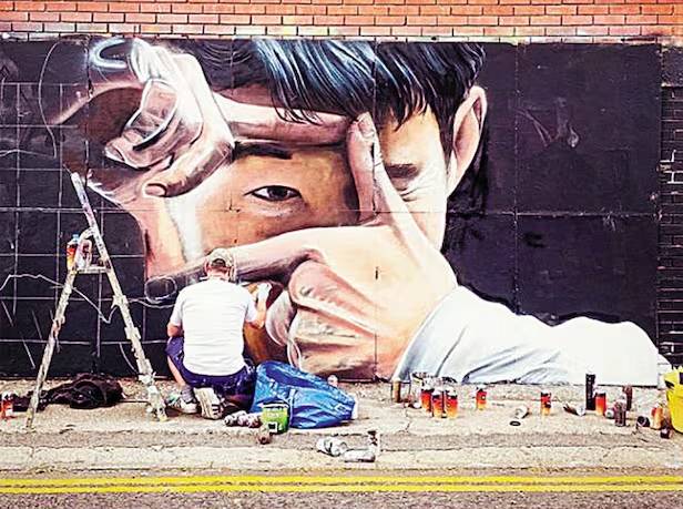 ▲ 지난 2022년 벽화 예술가 그내셔가 런던의 한 건물 외벽에 토트넘 홋스퍼의 손흥민을 그린 벽화를 작업하고 있는 모습. 이 벽화는 런던 시민들에게 손흥민을 다시 각인시켰다는 평을 들었다. ⓒ 스퍼스웹