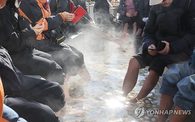 강추위도 녹이는 노천 족욕탕 (부산=연합뉴스) 강선배 기자 = 부산 지역 아침 최저기온이 영하로 떨어진 3일 해운대해수욕장 온천족욕탕을 찾은 어르신들이 따뜻한 온천물에 발을 담근 채 추위를 녹이고 있다. 2025.12.3 sbkang@yna.co.kr