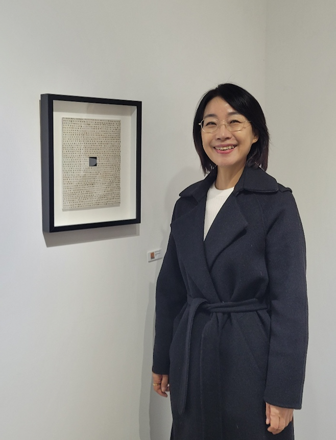 서영옥 미술평론가가 지난 4일 대구 중구 갤러리문101에 전시된 회화작품 옆에서 포즈를 취하고 있다. 전시작들은 서 평론가의 신간  서영옥이 만난 작가 Ⅱ에 소개된 작가들의 것이다. <임훈기자 hoony@yeongnam.com>