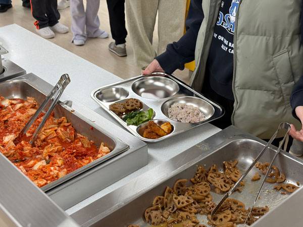 명현학교에서 한 학생이 식판에 스스로 음식을 뜨고 있다./사진=이슬비 기자