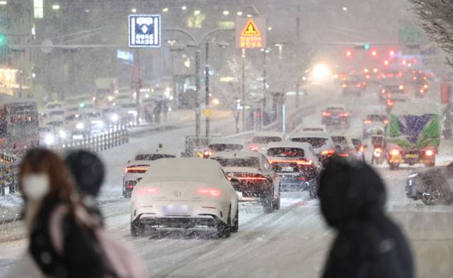 ▲ 서울·인천·경기·강원 등 4개 시도에 대설특보가 발효된 4일 서울 마포구 홍대 인근에서 제설작업이 완료되지 못한 곳을 지나는 차량이 힘겹게 언덕길을 오르고 있다. 2025.12.4 연합뉴스
