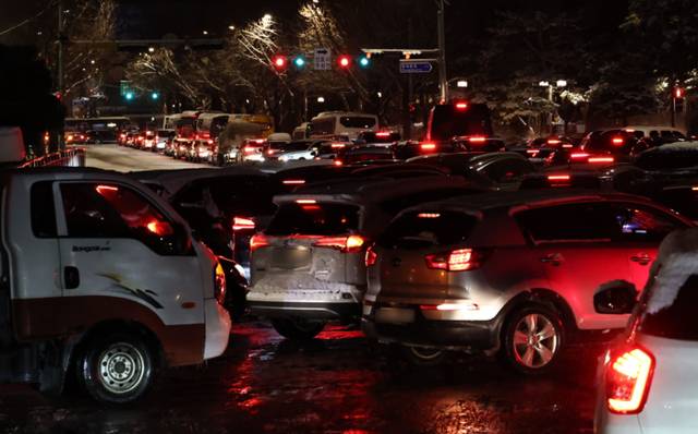 ▲ 올겨울 많은 양의 첫눈이 내린 4일 서울 종로구 청와대 사랑채 앞 도로에서 차량이 움직이지 못하고 있다. 2025.12.4 연합뉴스