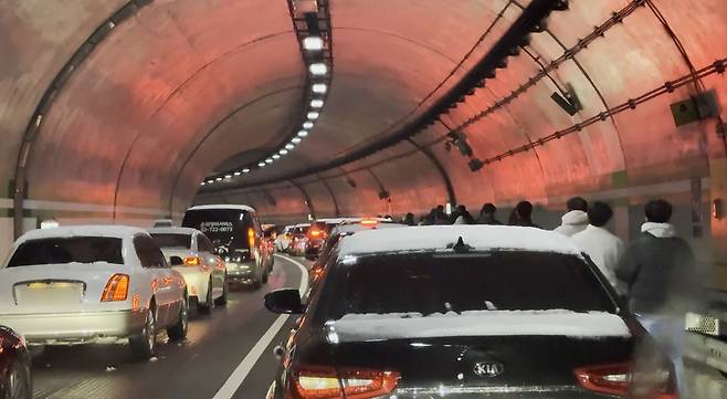 Commuters walk after getting off a bus at the Jahamun Tunnel in Jongno District, central Seoul, Dec. 4, as heavy snow warnings were issued for Seoul, Incheon, Gyeonggi and Gangwon. [YONHAP]