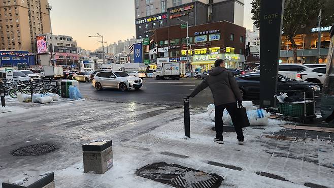 A commuter is seen grabbing onto a pole for balance near Seoul National University Station in Gwanak District, southern Seoul, on Dec. 5. [LEE GYU-RIM]