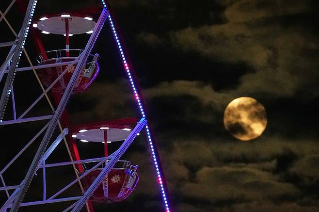 [니코시아=AP/뉴시스] 4일(현지 시간) 키프로스 니코시아 도심에서 올해 마지막 보름달인 슈퍼문이 크리스마스 마켓 대관람차 뒤로 떠오르고 있다. 2025.12.05.