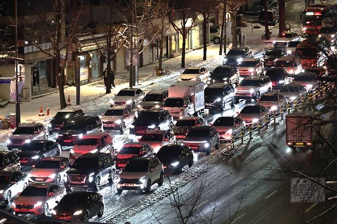 지난 4일 밤 서울 종로구 경복궁역 인근에서 시내로 향하는 차량이 눈길에 정체를 빚고 있는 모습. 연합뉴스