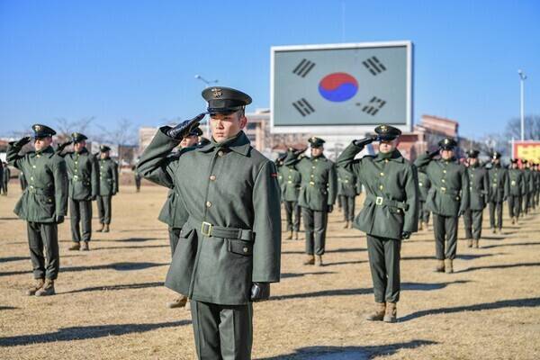 수료식에서 신병들이 국기에 대해 경례하고 있다.