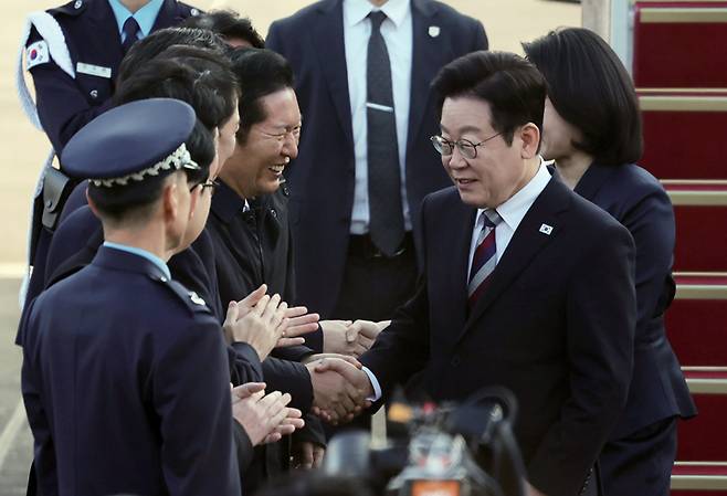 아프리카·중동 4개국 순방을 마치고 귀국한 이재명 대통령이 11월26일 성남 서울공항에서 정청래 더불어민주당 대표 등과 악수하고 있다. ⓒ연합뉴스