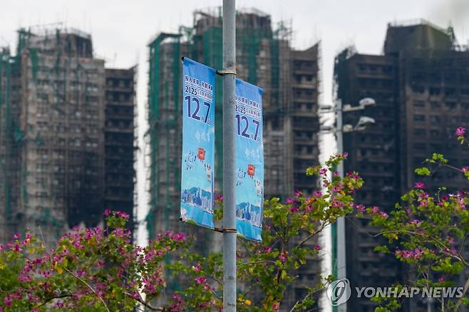 홍콩 아파트 화재참사 현장 근처에 걸린 입법회(의회) 의원 선거 홍보 현수막 [AP=연합뉴스]