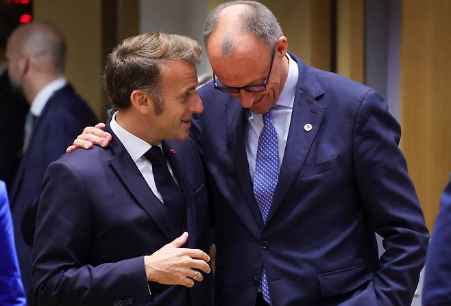 에마뉘엘 마크롱(왼쪽) 프랑스 대통령과 프리드리히 메르츠 독일 총리가 지난 10월 유럽연합 정상회의에서 친밀하게 대화하고 있다. 이들은 최근 유럽 정상들과 통화에서 미국에 대한 강한 불신을 드러낸 것으로 알려졌다./로이터 연합뉴스