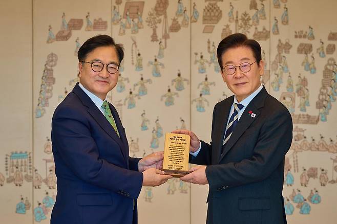 이재명 대통령이 3일 서울 용산 대통령실청사에서 열린 5부 요인 오찬에 참석한 우원식 국회의장으로부터 ‘빛의 민주주의 꺼지지 않은 기억패’를 선물받고 있다. 2025.12.3. 대통령실 제공